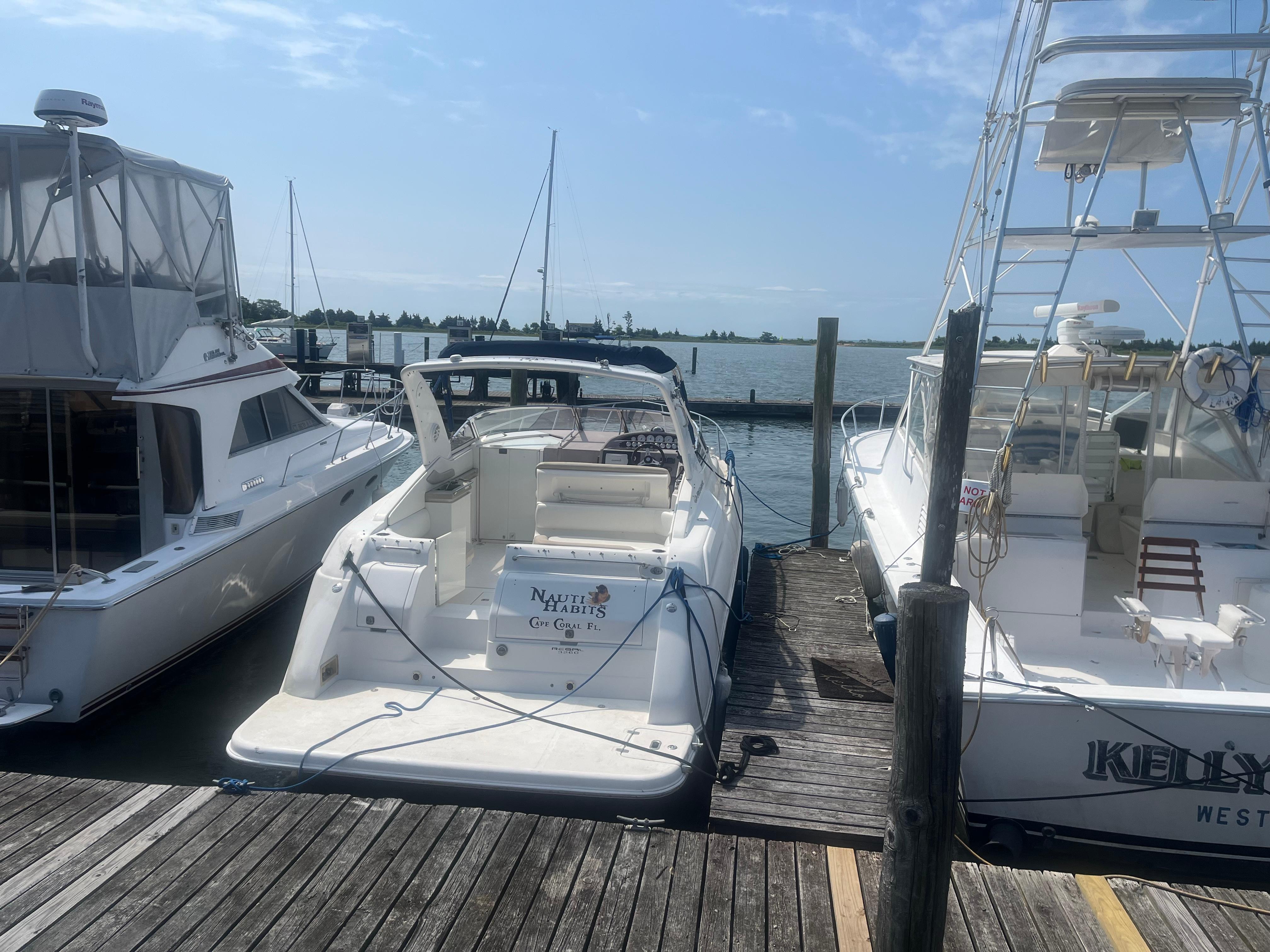 Regal 3260 Commodore 2003 Regal 3260 Commodore yacht docked between two boats at a marina.