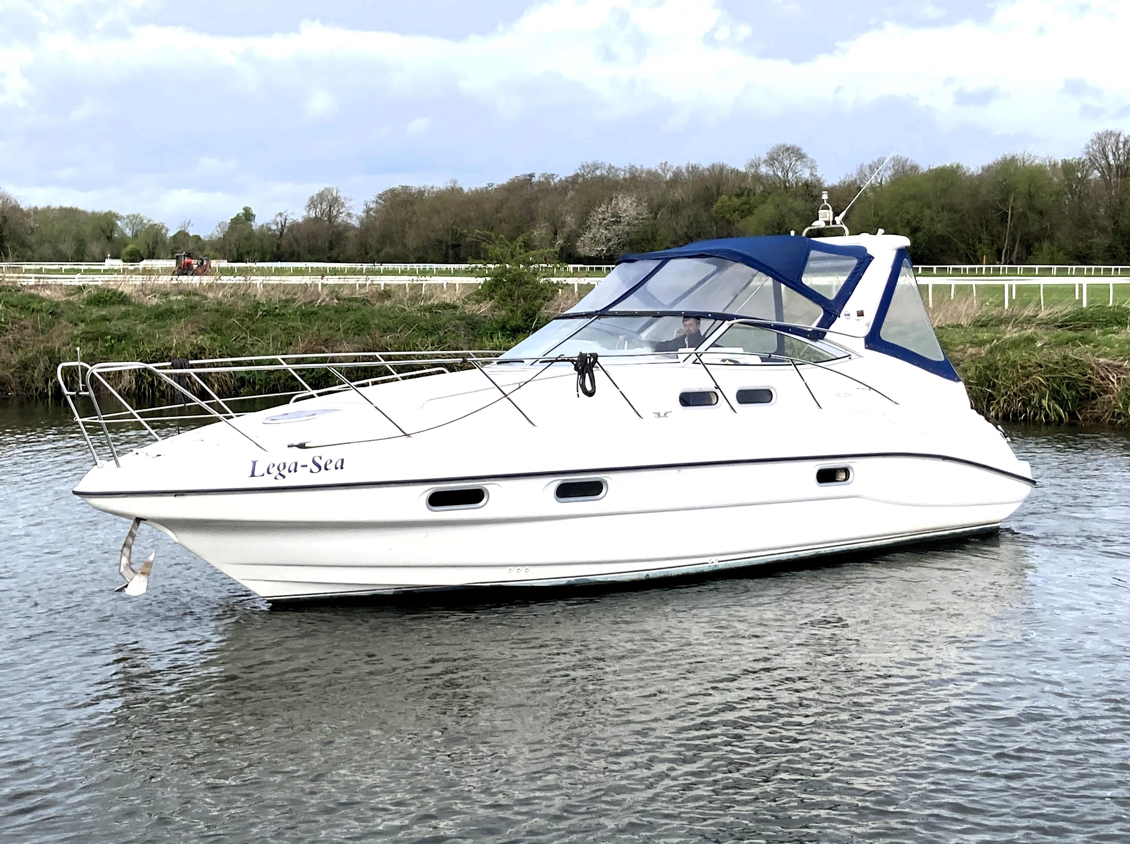 Sealine S34 1998 Sealine S34 boat named "Lega-Sea" cruising on a calm river.