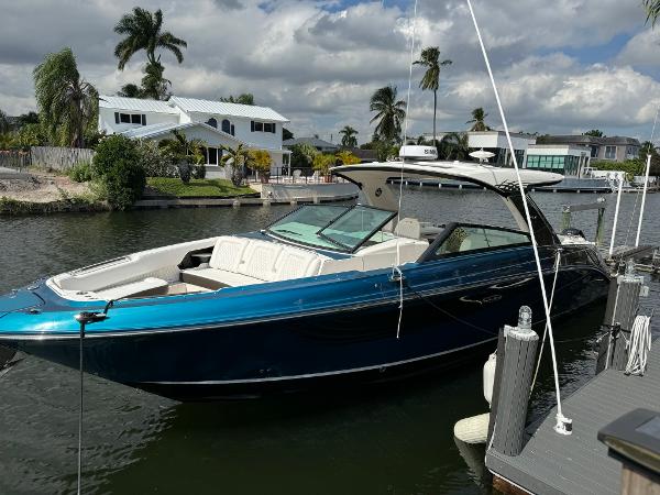 Sea Ray SLX 400 Outboard 2021 Sea Ray 400 SLX OB luxury boat docked in a scenic waterfront area.