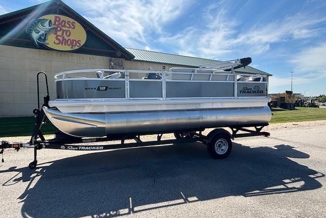 Sun Tracker Bass Buggy 18 DLX 2026 Sun Tracker Bass Buggy 18 DLX pontoon boat on trailer outside Bass Pro Shops.