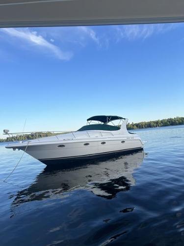 Cruisers Yachts 3375 Esprit 1999 Cruisers Yachts 3375 Esprit on calm lake under clear blue sky.