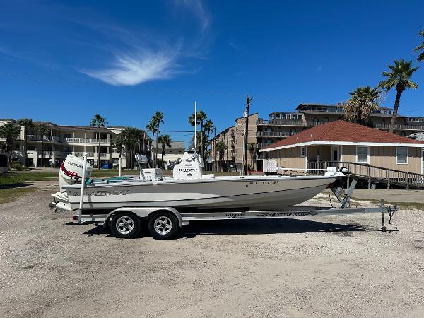 Blazer 2220 2015 Blazer 2220 boat on a trailer in a coastal area with buildings and palm trees.