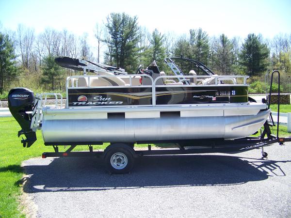 Sun Tracker Bass Buggy 16 XL 2021 Sun Tracker Bass Buggy 16 XL pontoon boat on trailer, parked outdoors.