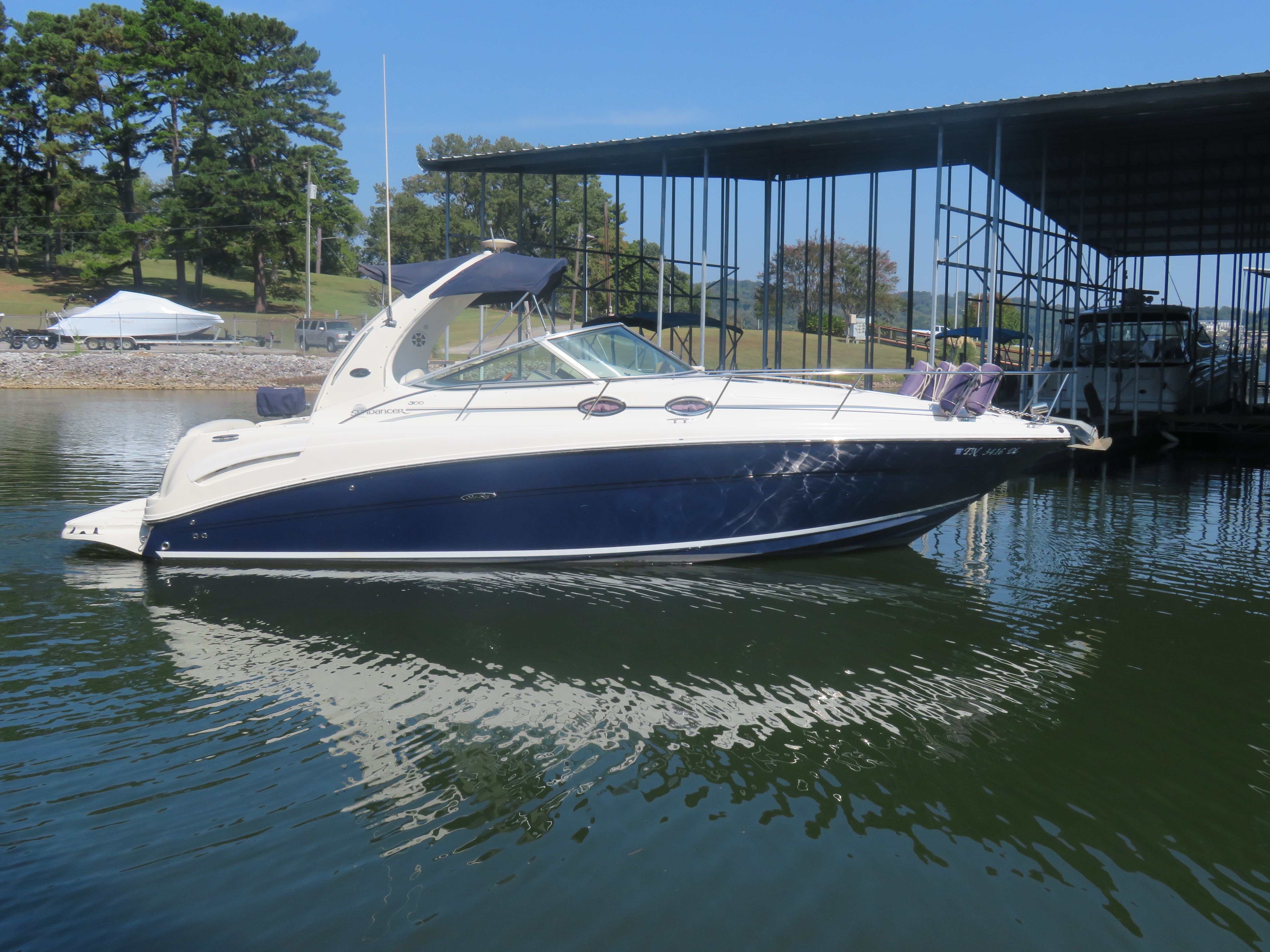 Sea Ray 300 Sundancer 2005 Sea Ray 300 Sundancer boat docked on calm water, surrounded by trees and a marina.