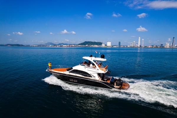Sea Ray SEDAN BRIDGE 520 2005 Sea Ray Sedan Bridge 520 yacht cruising on calm blue waters near a city skyline.