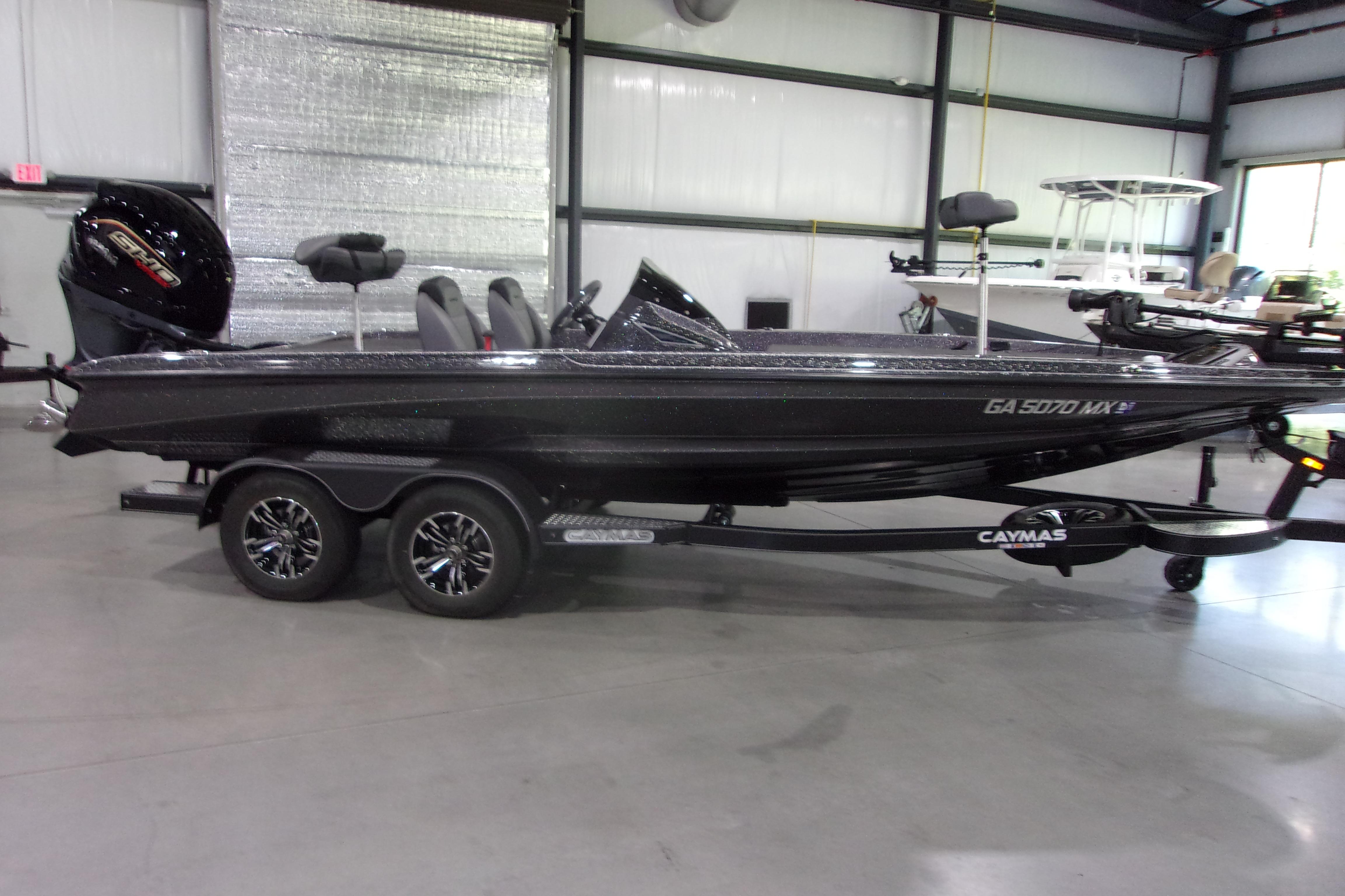 Caymas CX-20 PRO 2022 Caymas CX-20 PRO boat in showroom, featuring sleek design and dual-axle trailer.