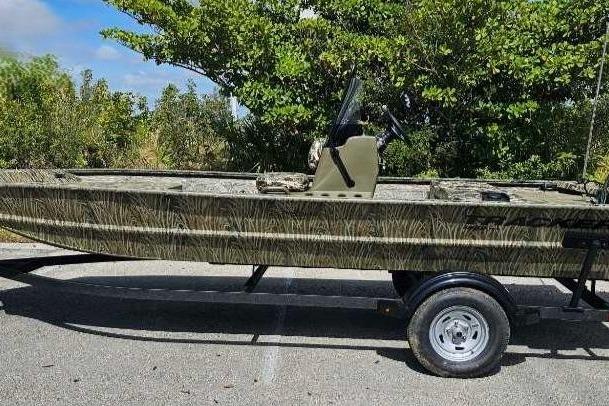 Tracker Grizzly 1860 CC 2025 Tracker Grizzly 1860 CC boat on trailer, camo design, parked outdoors.