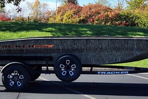 Tracker Grizzly 1756 T Marsh 2026 Tracker Grizzly 1756 T Marsh boat on trailer, camo design, parked outdoors.