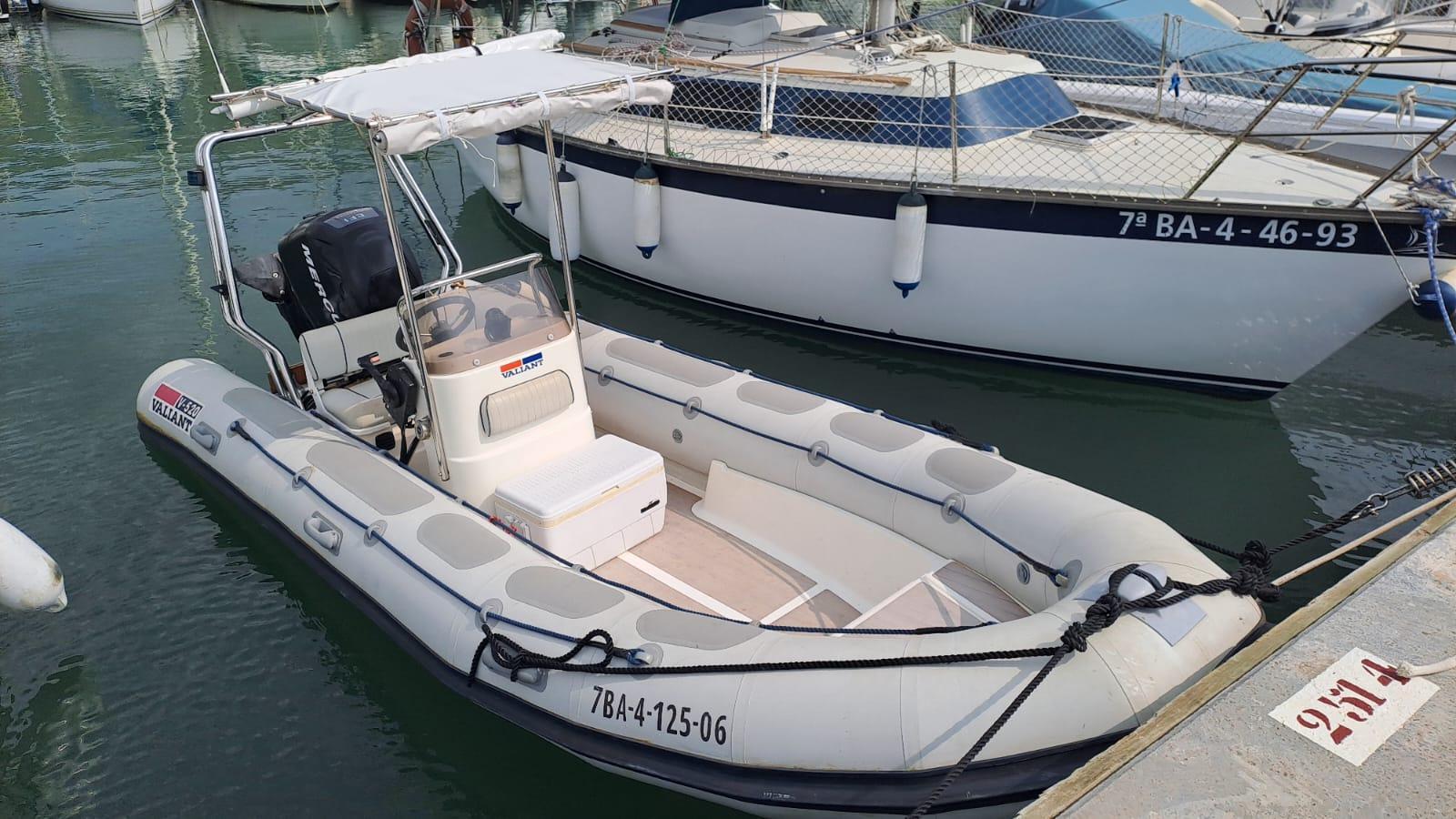Valiant 520 2005 Valiant 520 inflatable boat docked in marina, featuring a canopy and outboard motor.