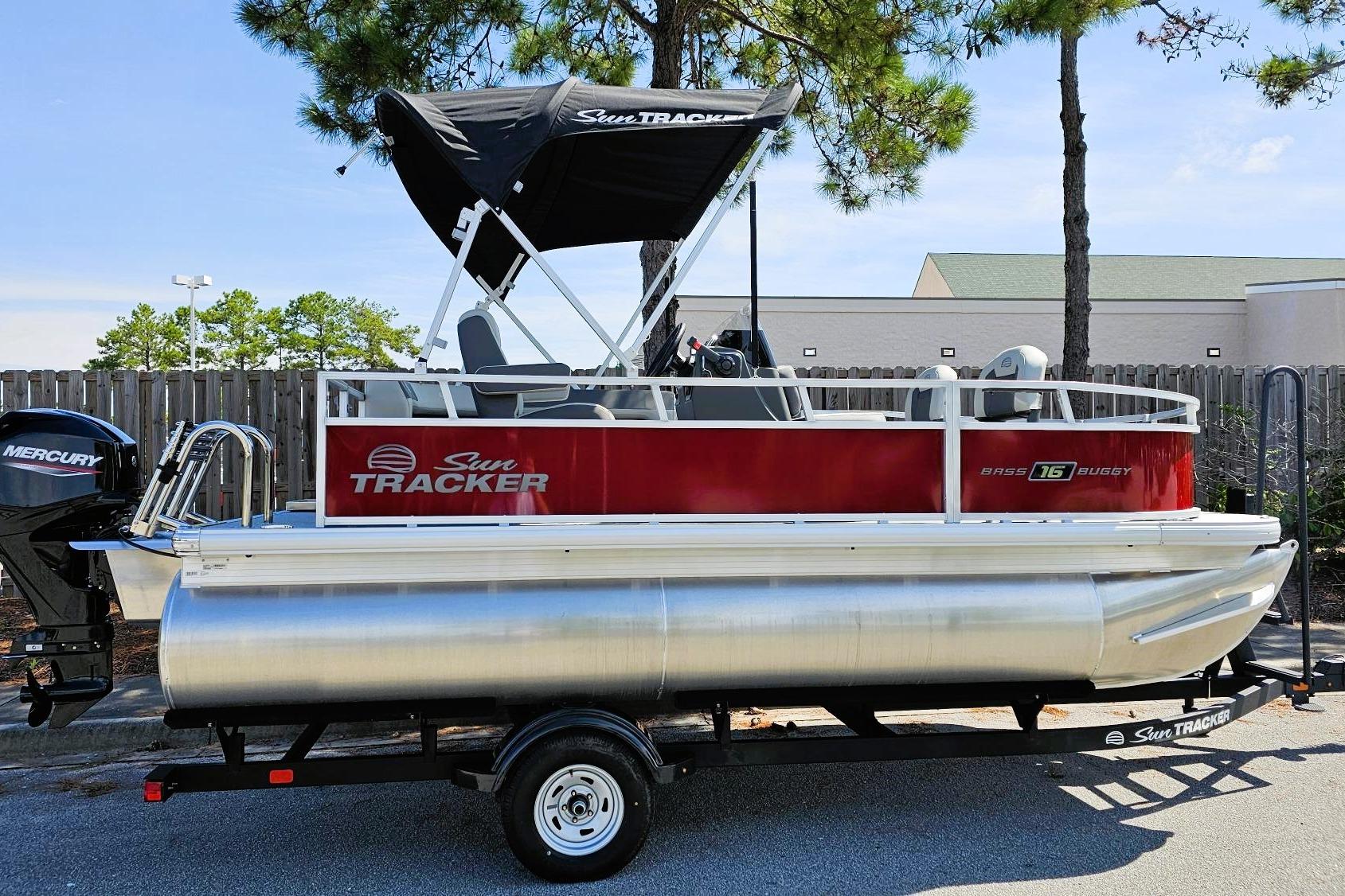 Sun Tracker Bass Buggy 16 XL Select 2026 Sun Tracker Bass Buggy 16 XL Select pontoon boat with Mercury engine, parked outdoors.