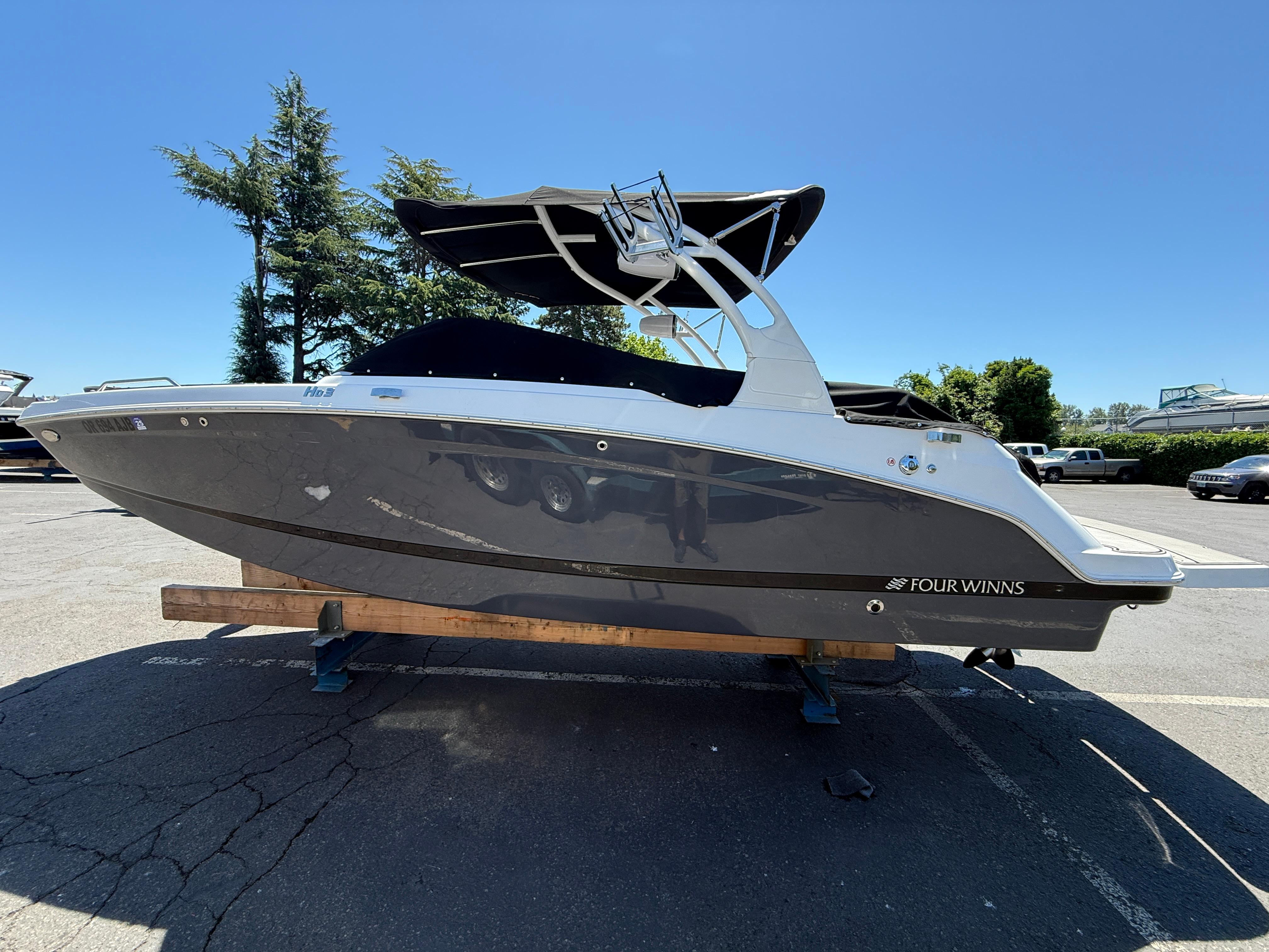 Four Winns HD3 Surf 2023 Four Winns HD3 Surf boat on display in a parking lot.