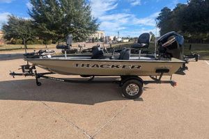 Tracker Pro Team 175 2026 Tracker Pro Team 175 boat on trailer in parking lot, sunny day.