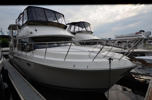 Carver 406 2001 Carver 406 yacht docked at marina under cloudy sky.