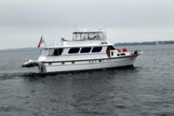 Matthews Extended Deck House 1971 Matthews Motor Yacht cruising on a calm, overcast sea.