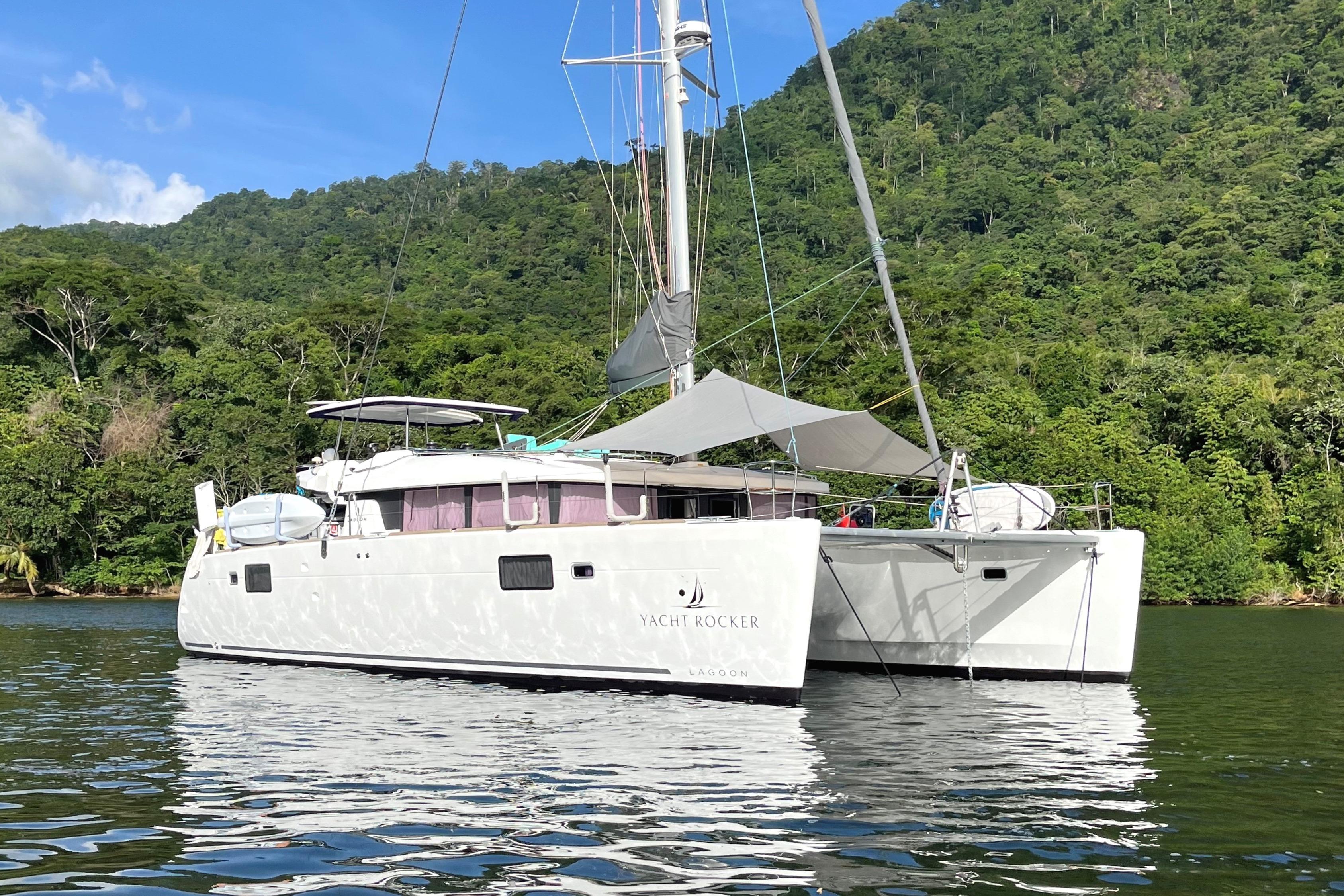 Lagoon 450 s 2018 Lagoon 450 s catamaran anchored in scenic tropical waters with lush green hills.