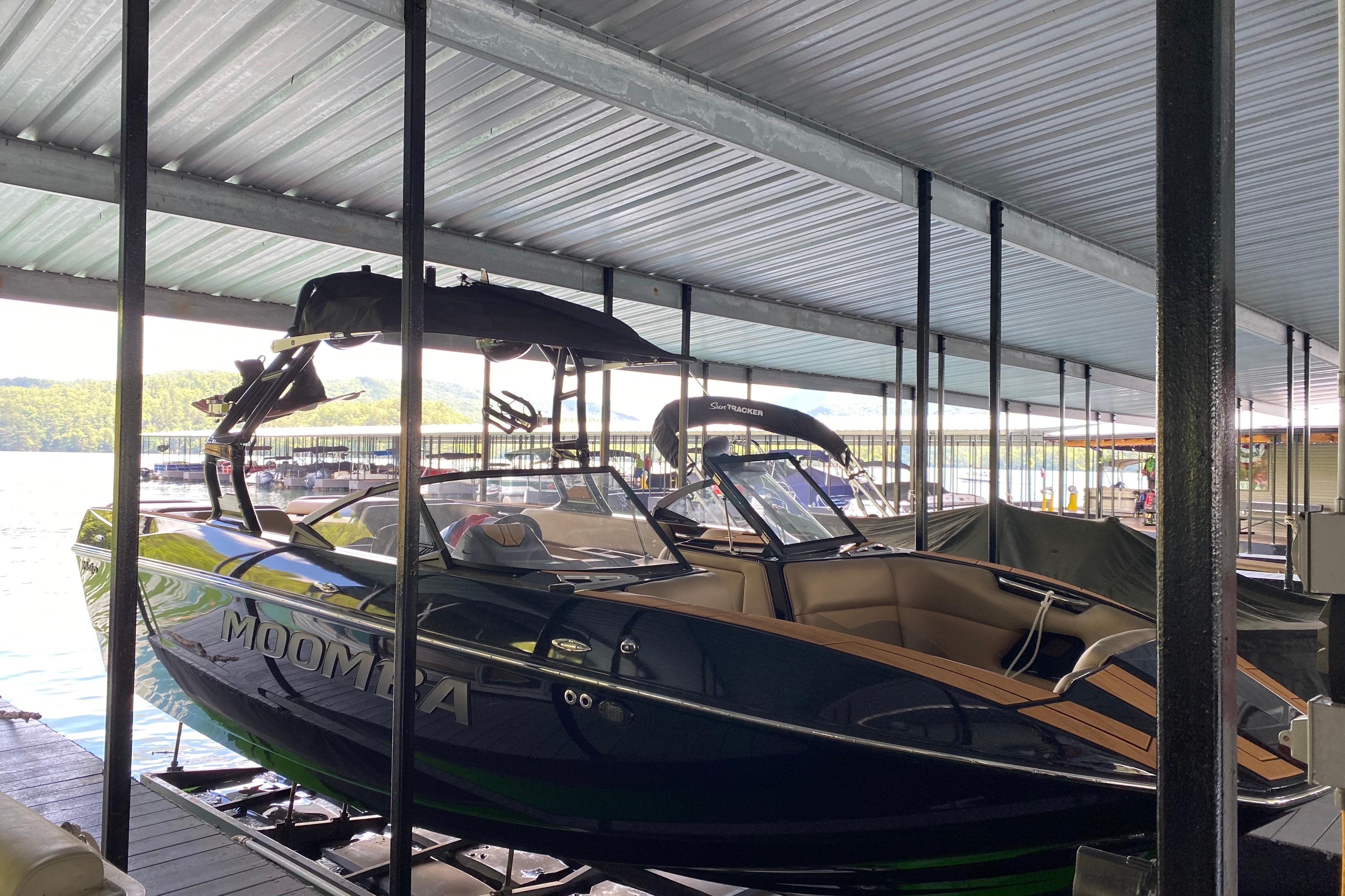 Moomba Mojo 2022 Moomba Mojo boat docked in a covered marina, showcasing sleek design and modern features.