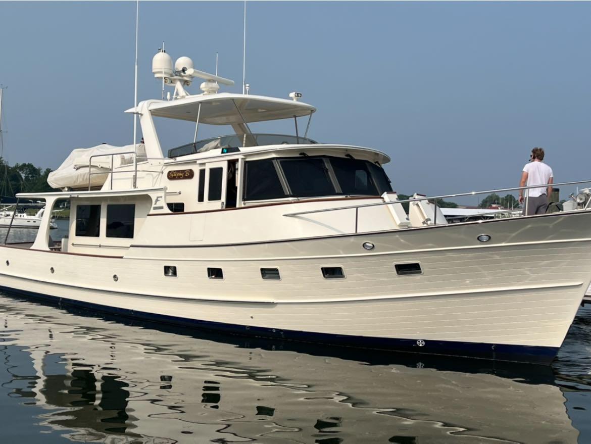Fleming Pilothouse 2014 Fleming Pilothouse yacht docked with a person on deck.