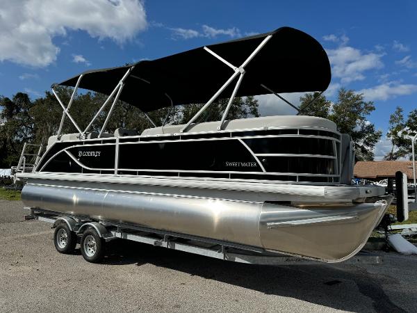 Sweetwater 2286 SB 2025 Sweetwater 2286 SB pontoon boat with black canopy on a trailer.
