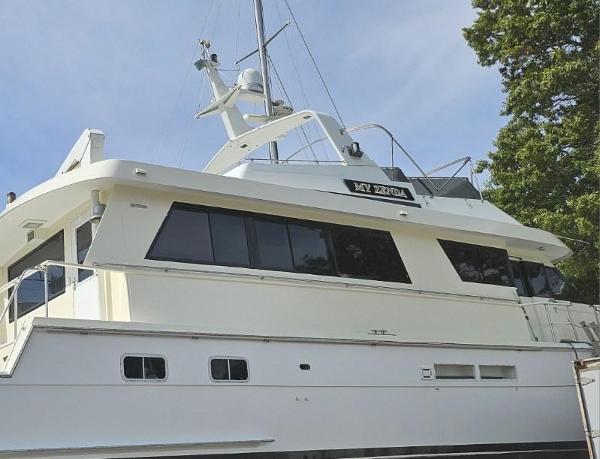 Hatteras Cockpit Motor Yacht 1991 Hatteras Cockpit Motor Yacht, white exterior, docked, side view, clear sky, trees in background.