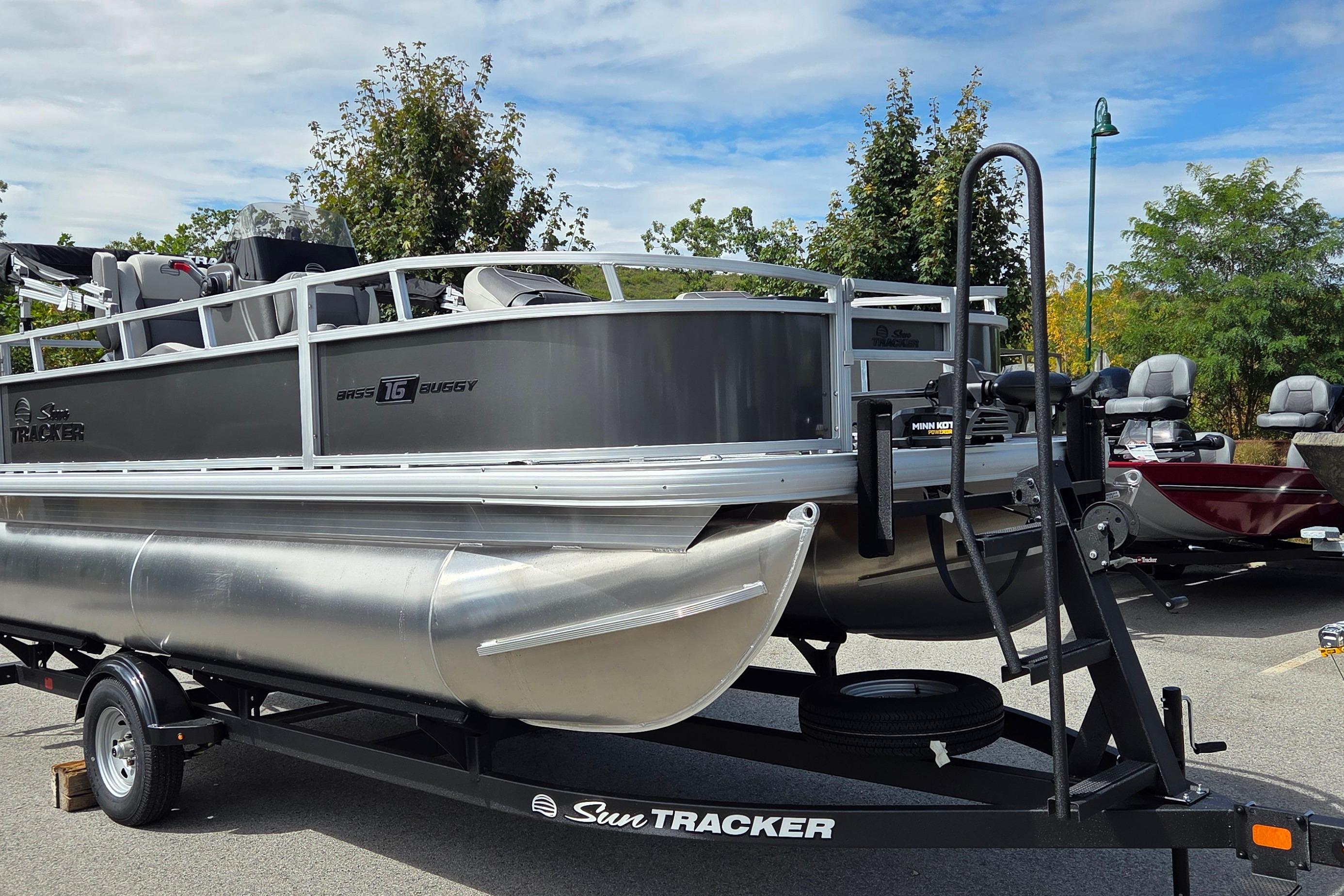 Sun Tracker Bass Buggy 16 XL Select 2026 Sun Tracker Bass Buggy 16 XL Select pontoon boat on trailer, parked outdoors.
