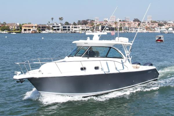 Pursuit 345 Offshore 2015 Pursuit 345 Offshore boat cruising on a sunny day near coastal homes.