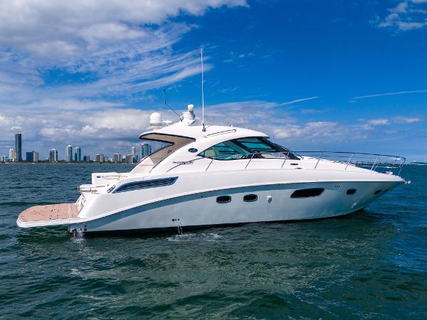 Sea Ray 470 Sundancer 2011 Sea Ray 470 Sundancer yacht cruising on open water with city skyline backdrop.