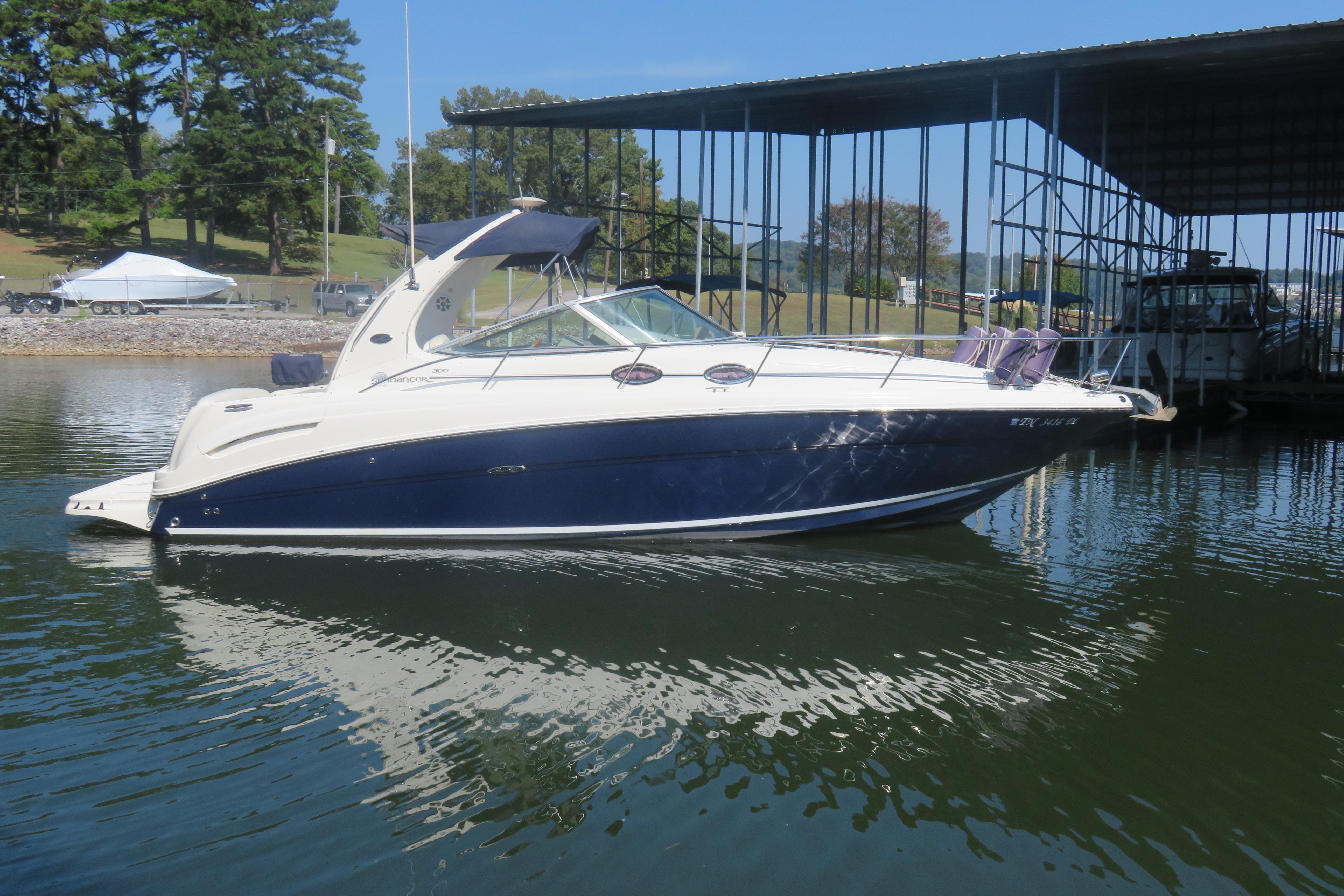Sea Ray 300 Sundancer 2005 Sea Ray 300 Sundancer boat docked on calm water under clear blue sky.