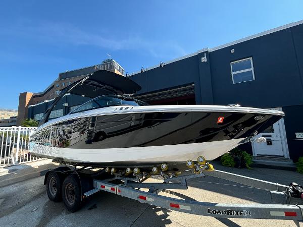 Regal LX6 2024 Regal LX6 boat on trailer, sleek black and white design, parked outdoors.