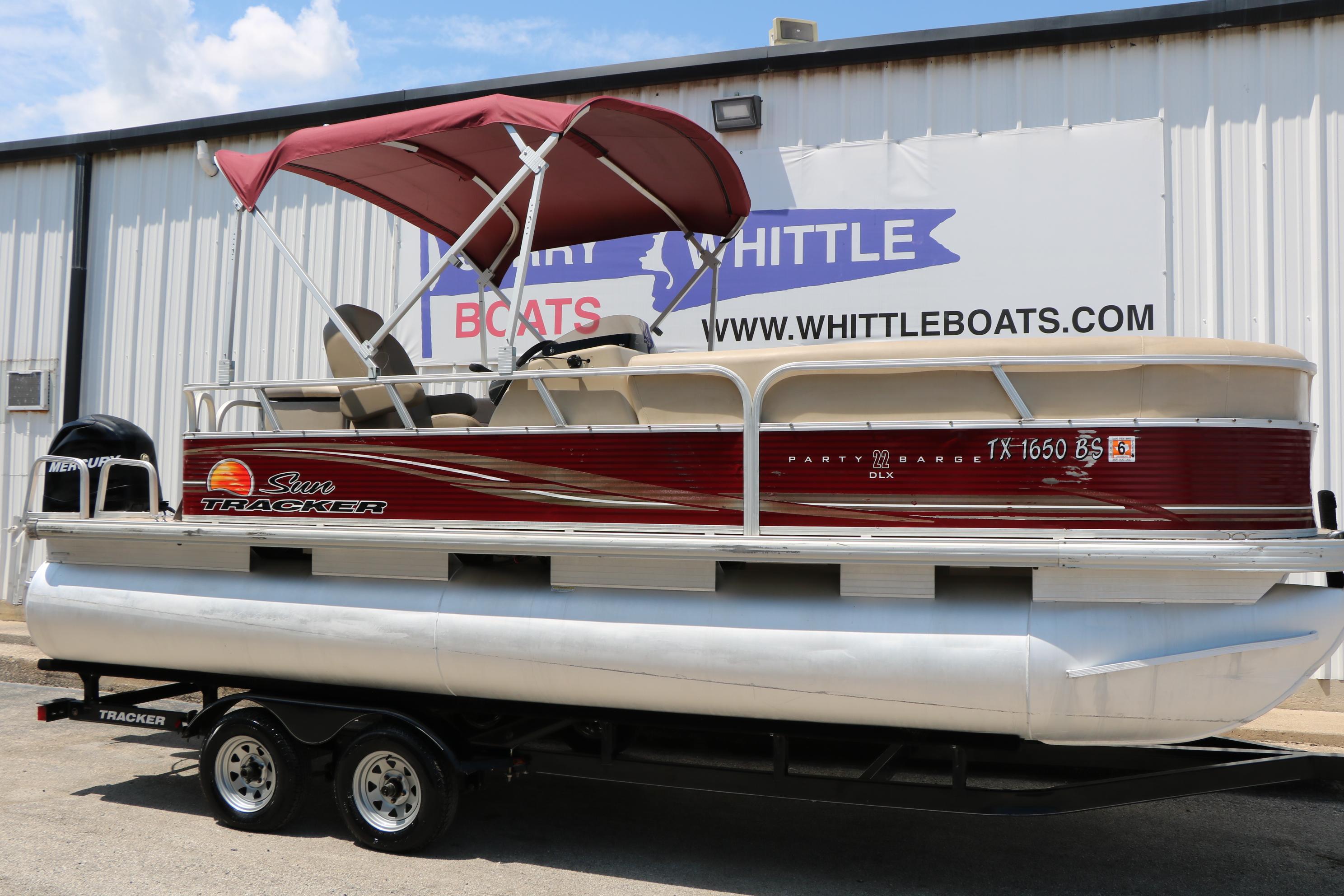 Sun Tracker Party Barge 22 DLX 2012 Sun Tracker Party Barge 22 DLX pontoon boat with red canopy on trailer.