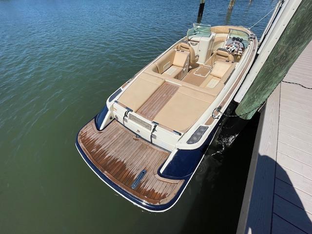 Chris-Craft Launch 25 2011 Chris-Craft Launch 25 boat docked on calm water, featuring elegant wood detailing.