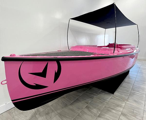 Vision Marine Technologies Fantail 217 2024 Vision Marine Technologies Fantail 217, pink electric boat with canopy, displayed indoors.