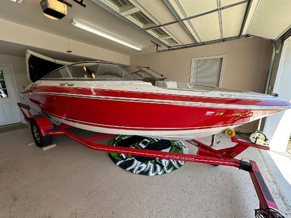 Four Winns H200 2007 Four Winns H200 red boat on trailer in garage.