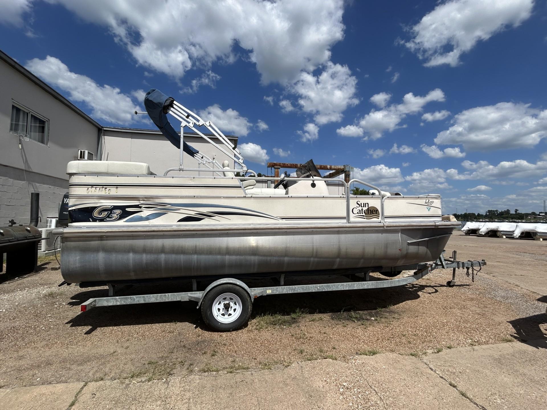 SunCatcher LX 20 Fish & Cruise 2006 SunCatcher LX 20 Fish & Cruise pontoon boat on trailer, under blue sky.
