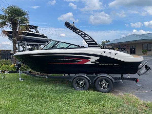 Chaparral 21 SSi 2025 Chaparral 21 SSi boat on trailer, parked outdoors near palm tree.