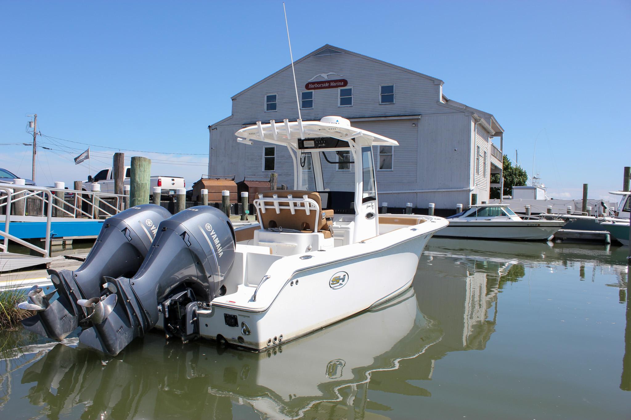 Sea Hunt Gamefish 25 2020 Sea Hunt Gamefish 25 boat docked at marina with twin Yamaha engines.