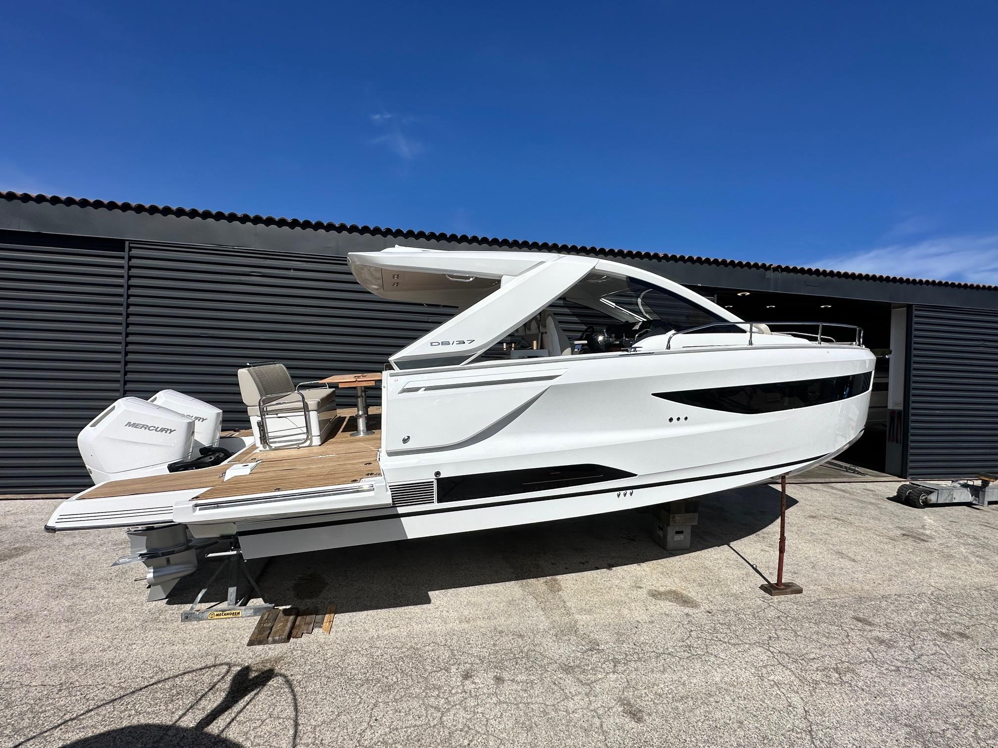 Jeanneau DB/37 OB 2025 Jeanneau DB/37 OB boat with Mercury outboard, docked under clear blue sky.