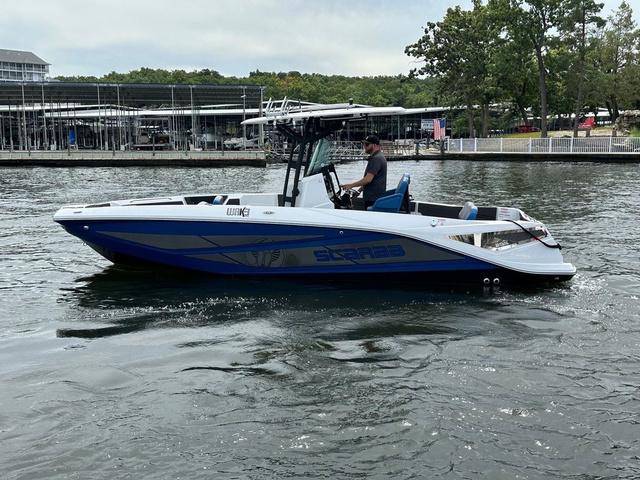 Scarab SB255 2025 Scarab SB255 boat cruising on a lake near a marina.