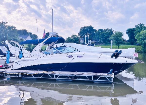 Sea Ray 320 Sundancer 2006 Sea Ray 320 Sundancer yacht docked on a calm river under a cloudy sky.