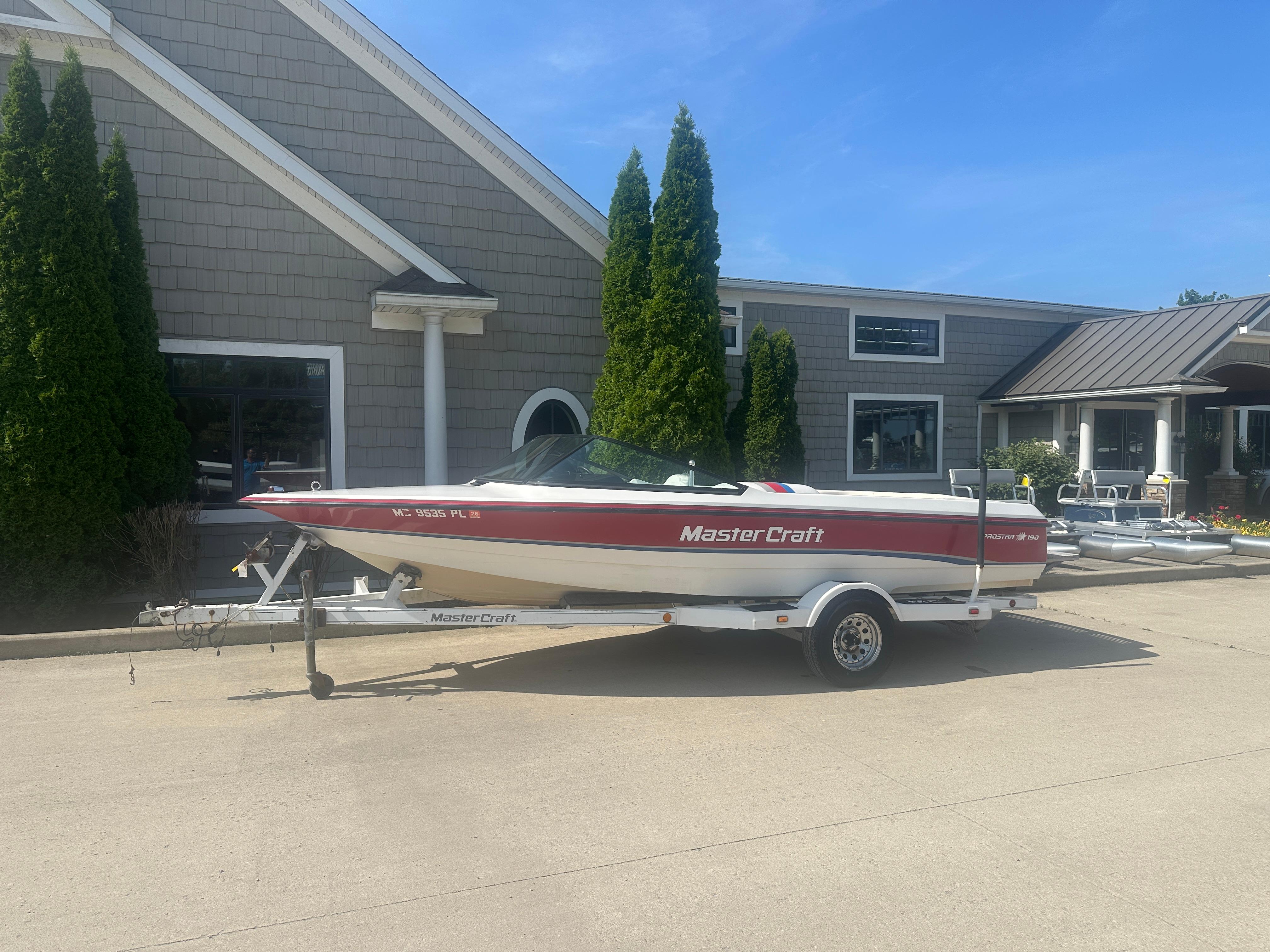 MasterCraft ProStar 190 1993 MasterCraft ProStar 190 boat on trailer, parked outside a building on a sunny day.