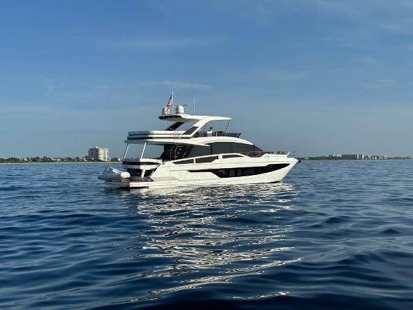 Galeon 640 Fly 2019 Galeon 640 Fly yacht on calm ocean waters, clear sky background.