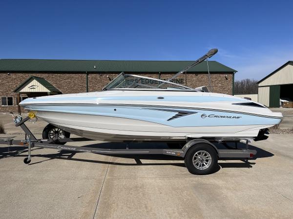 Crownline 210SS 2023 Crownline 210SS boat on a trailer, parked outdoors.