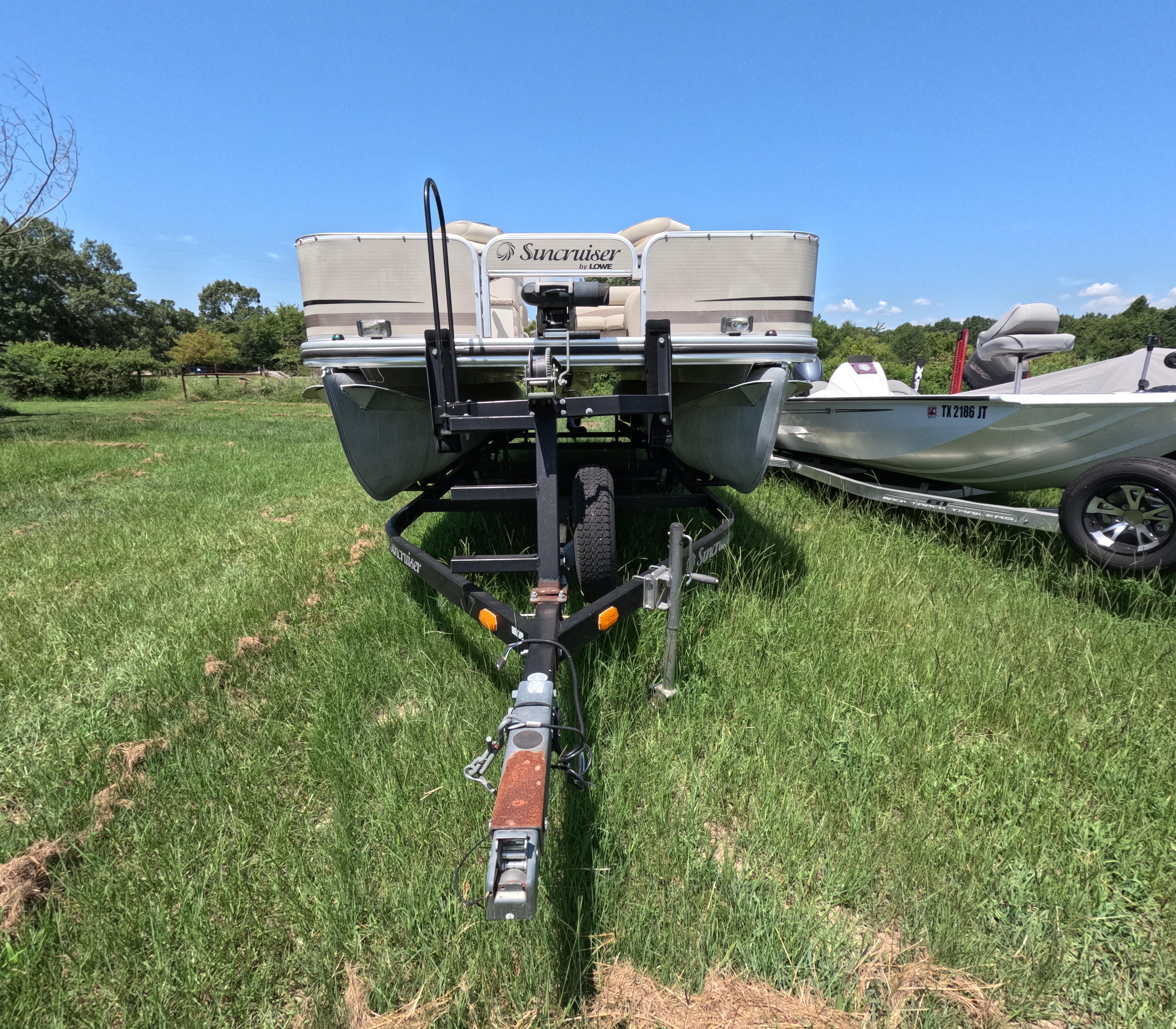 Lowe Suncruiser SF214 2011 Lowe Suncruiser SF214 pontoon boat on trailer, parked on grassy field.
