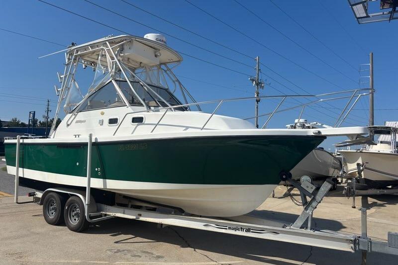 Shamrock 260 Express 2000 Shamrock 260 Express boat on trailer, green and white hull, parked outdoors.