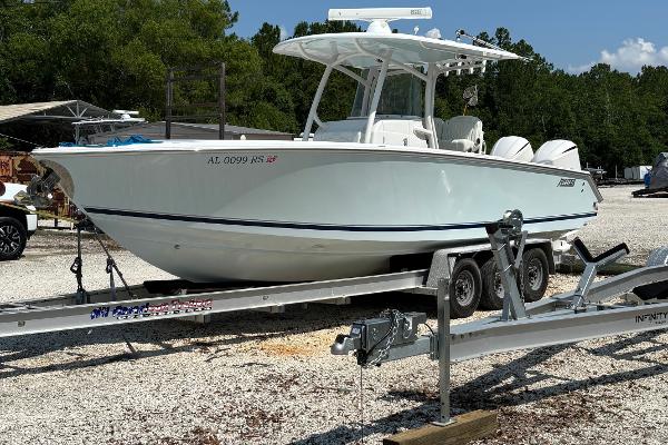 Jupiter 30 FS 2012 Jupiter 30 FS boat on trailer, parked outdoors, surrounded by trees.