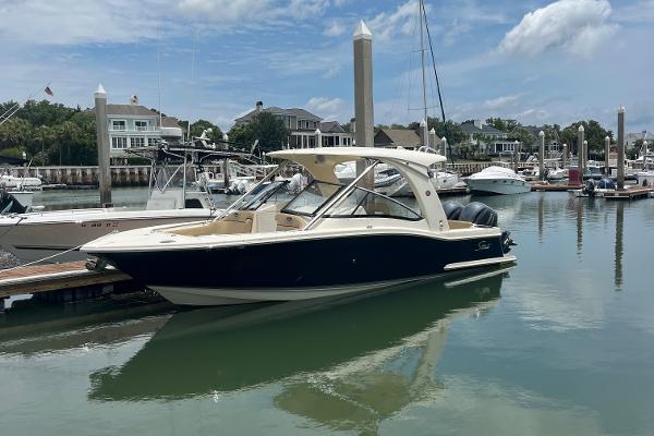 Scout 275 Dorado 2015 Scout 275 Dorado boat docked in a marina with clear skies.