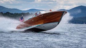 Riva Reets Replica Super Aquarama 2018 Riva Reets Replica Super Aquarama speedboat cruising on a lake with mountains in the background.