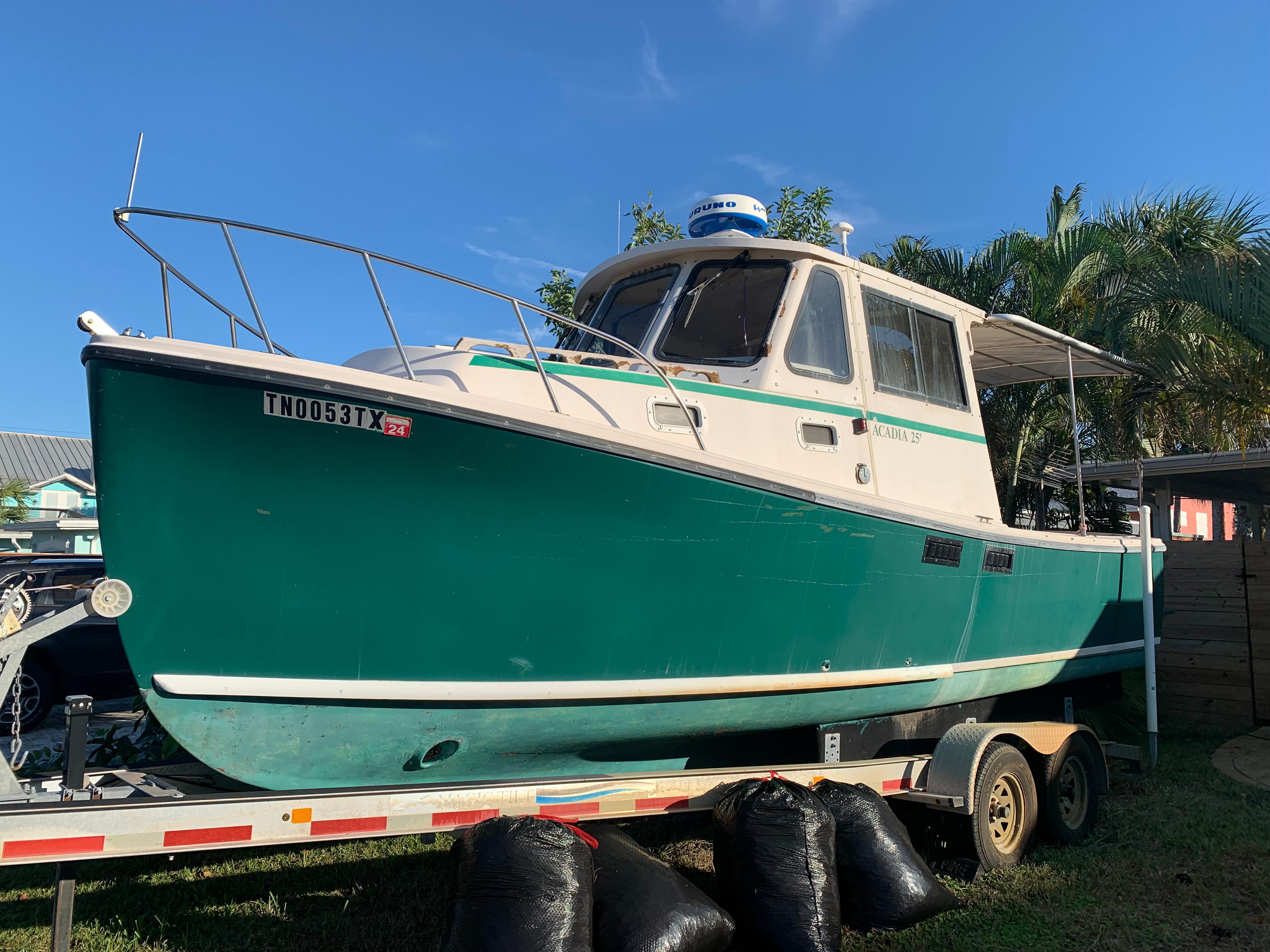 Atlas Acadia 1998 Atlas Acadia boat on trailer, green and white, sunny day, palm trees in background.