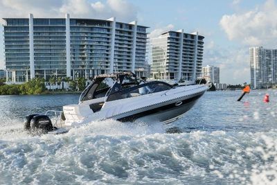 Hanover 305 Outboard 2025 Hanover 305 Outboard boat cruising in urban waterfront setting with modern buildings.