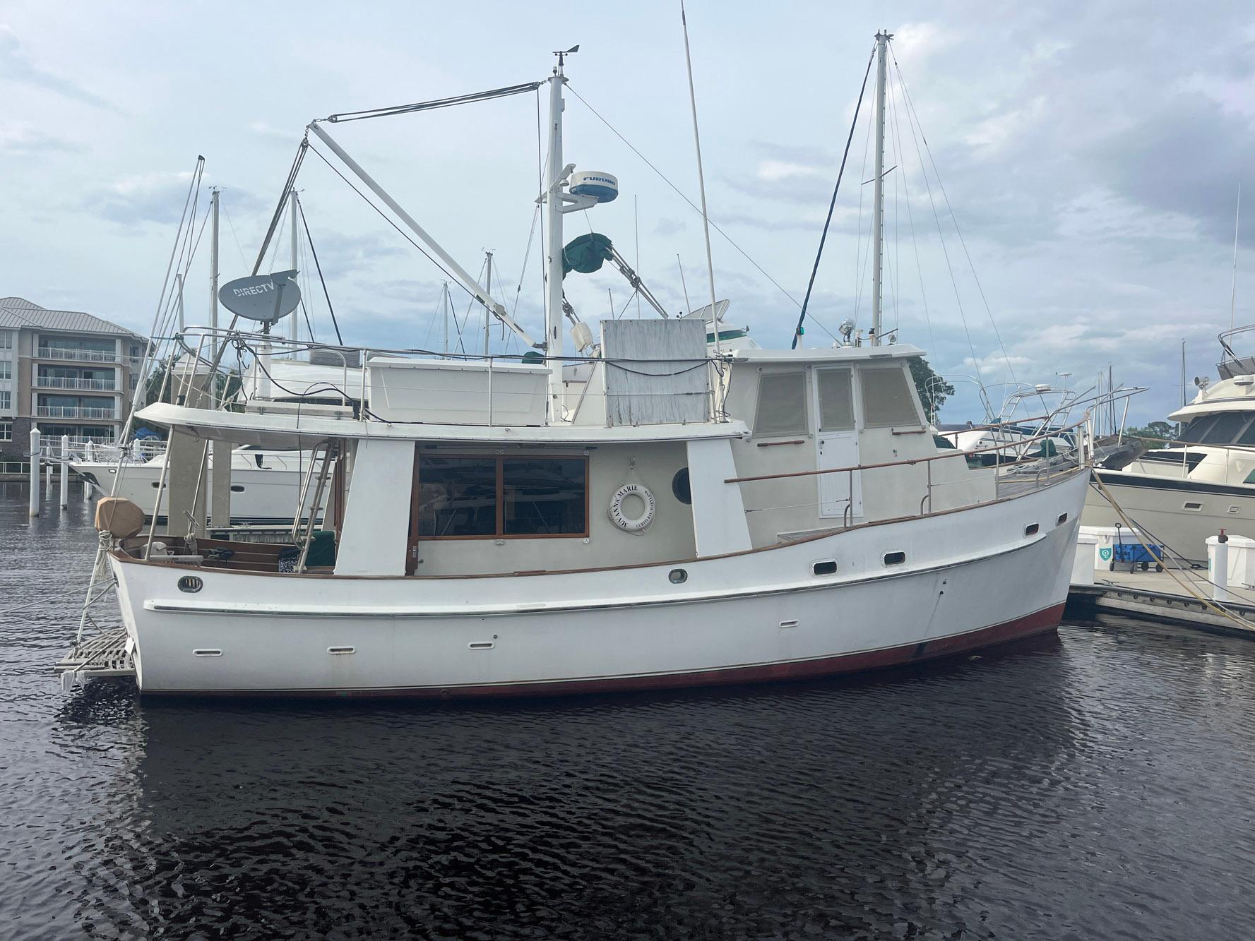 Kadey-Krogen 42 1987 Kadey-Krogen 42 yacht docked at marina under cloudy sky.