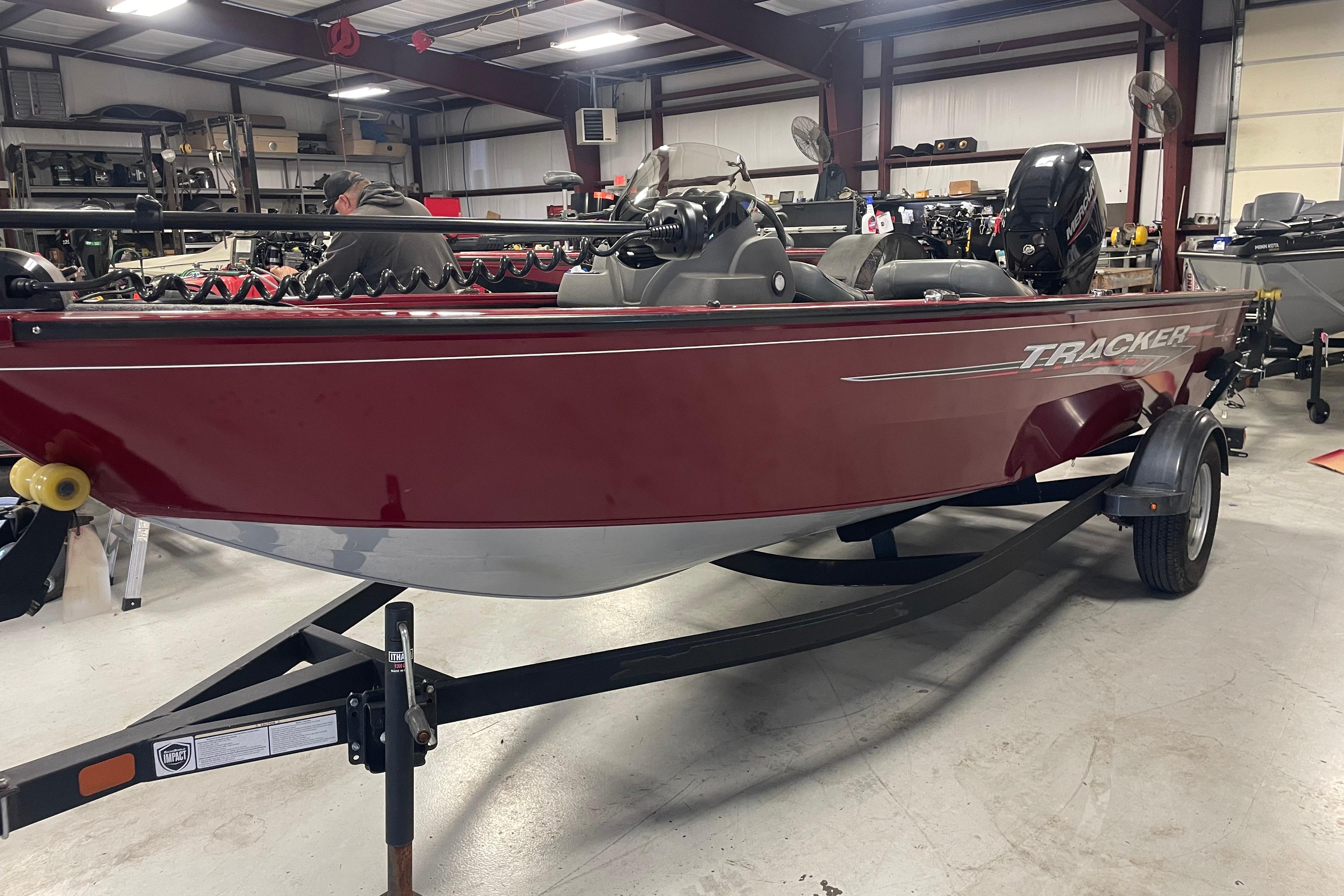 Tracker Pro Guide V-16 SC 2021 Tracker Pro Guide V-16 SC boat in a showroom, red exterior.
